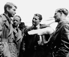 Илл.4 . Май 1945 г. Вернер фон Браун (в центре) беседует с представителями американских оккупационных властей. (Левая рука Брауна сломана в недавней автоаварии)